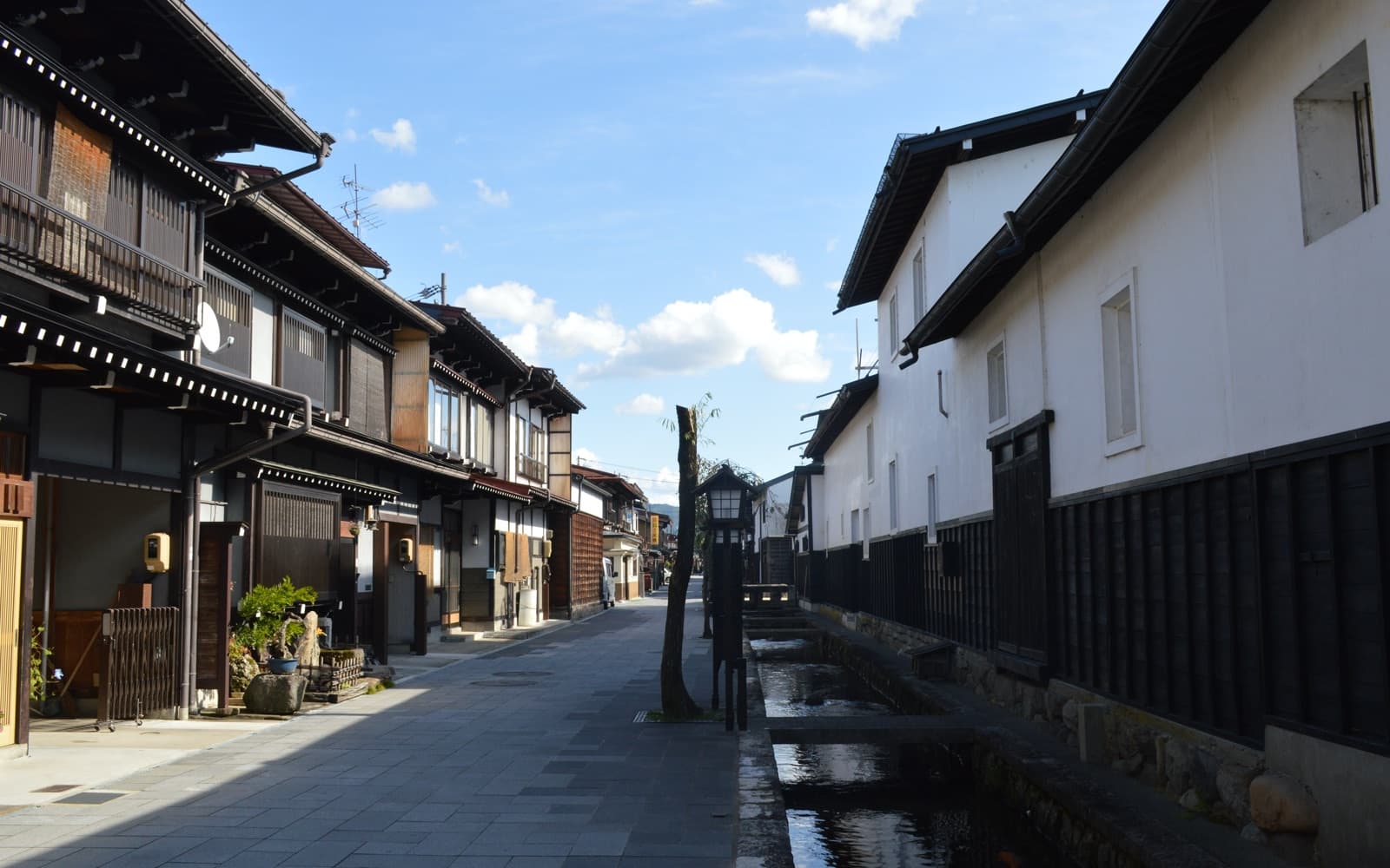 The Seto Canal running beside white-walled storehouses on a sunny day in Hida-Furukawa, Gifu Prefecture