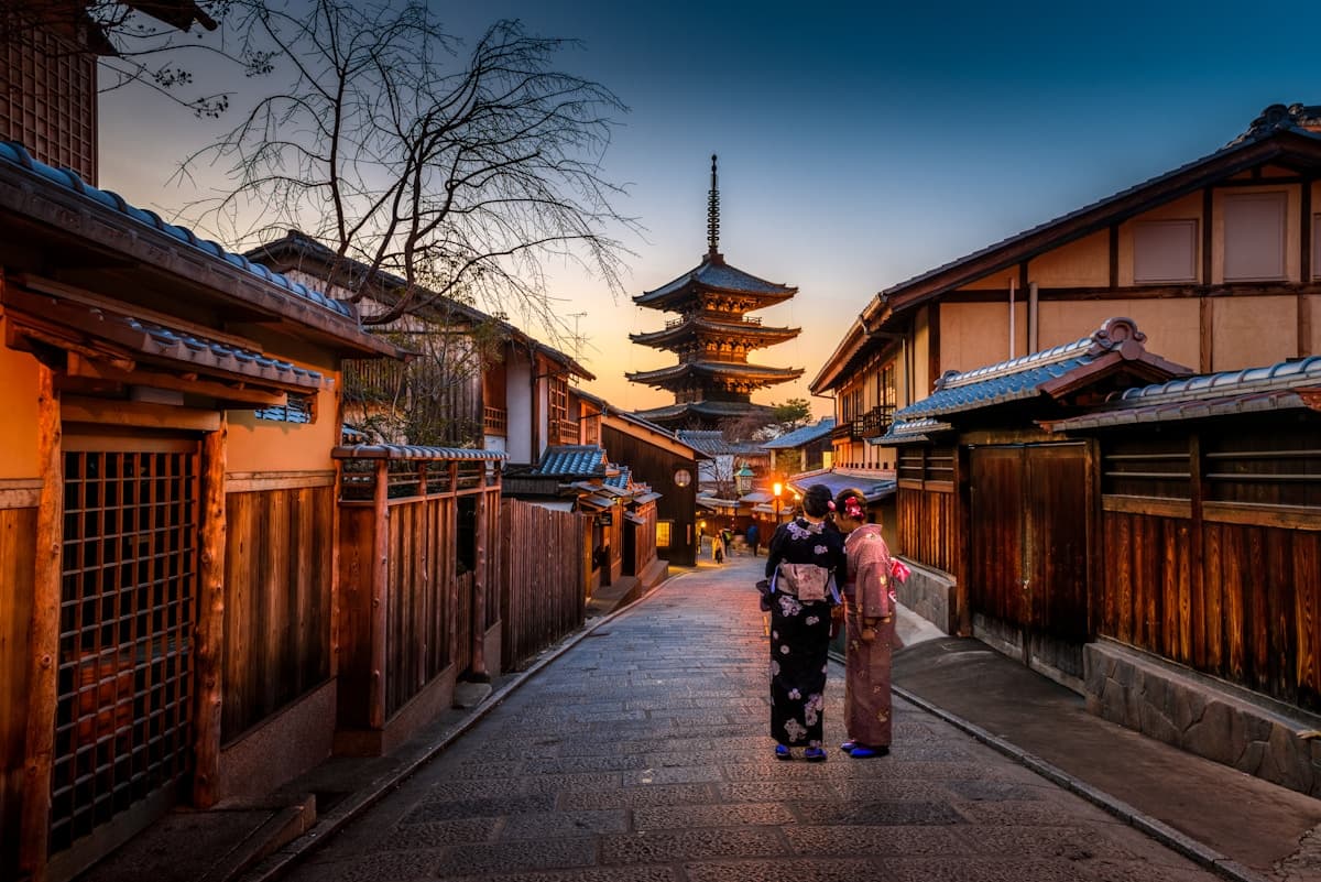 Two women in kimono walking through a historic Kyoto street