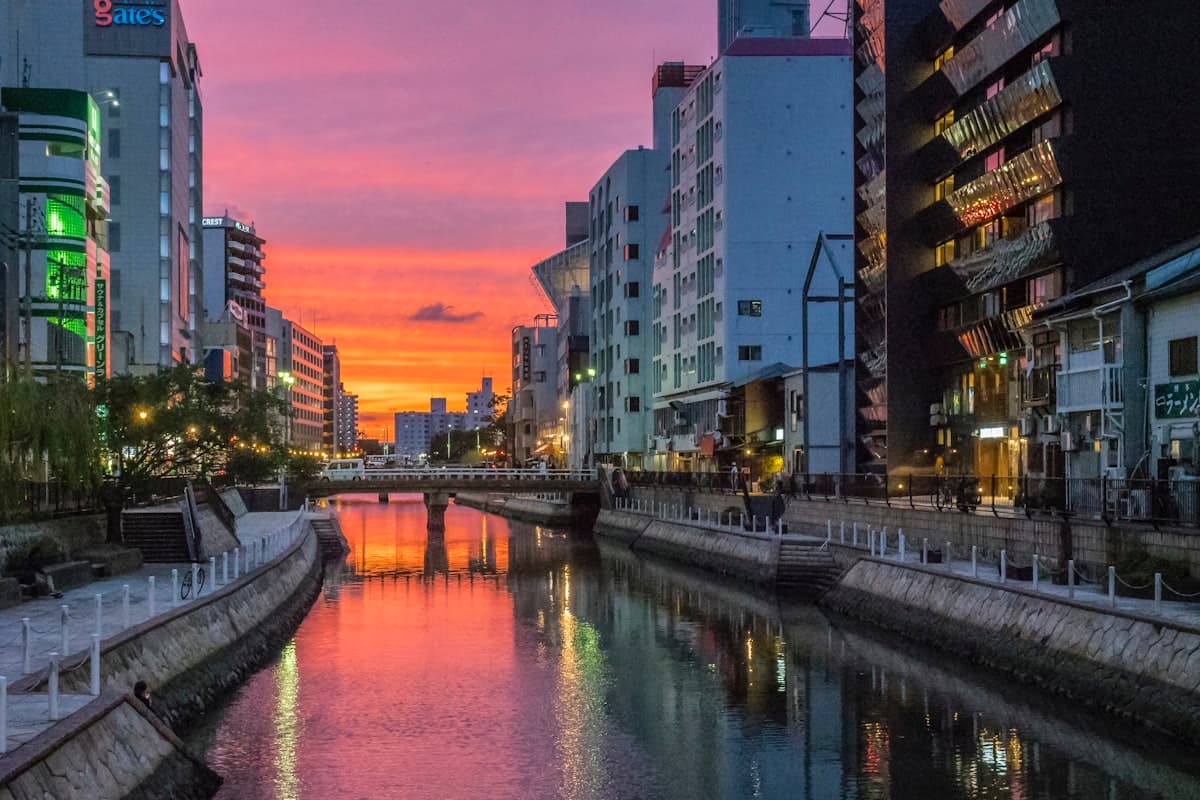 The Naka River at night with illuminated high-rise buildings lining both banks.