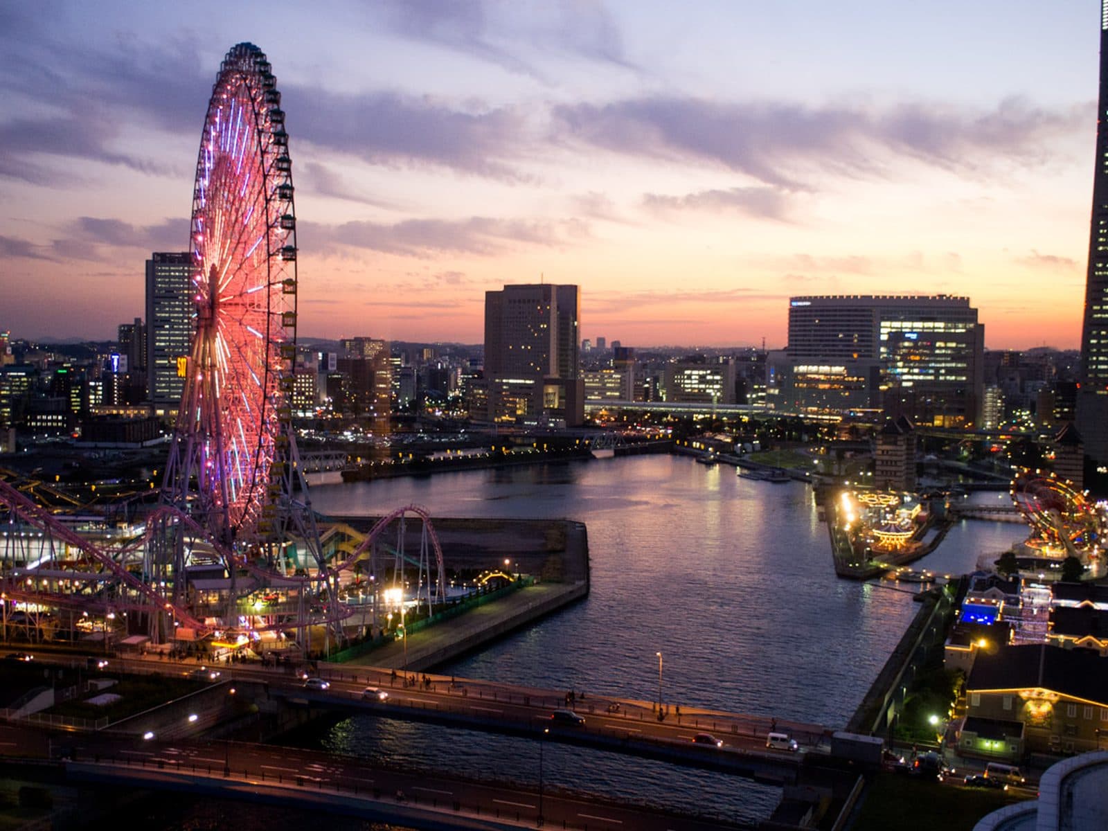 The red Tempozan Ferris wheel at dusk, with the Osaka Bay skyline behind it.