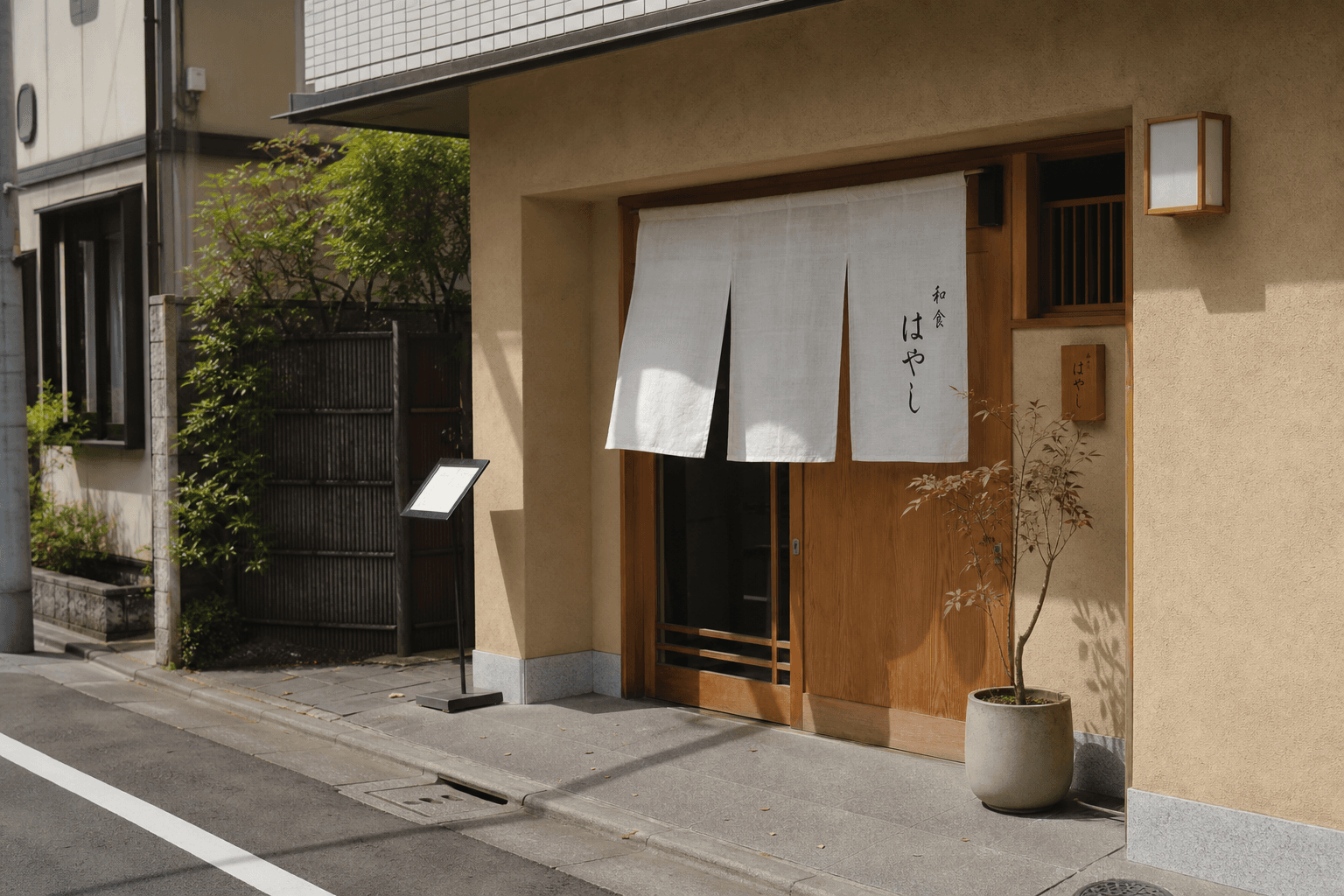 A single small restaurant entrance with a fabric noren curtain above a wooden door on a calm daylight sidewalk.
