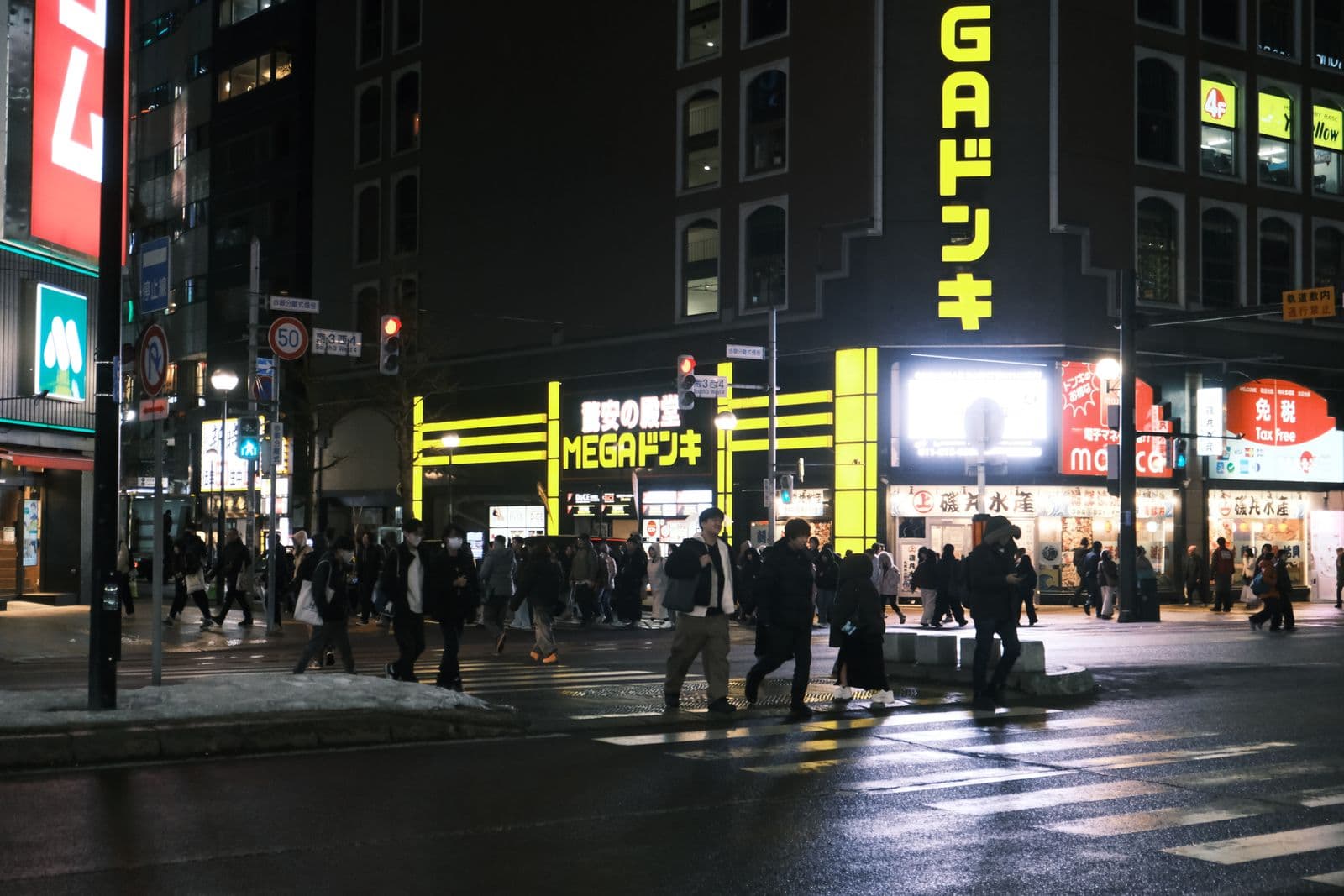 Pedestrians walk a lighted Sapporo shopping street at night — an ordinary city evening with storefront glow and foot traffic, not a TV Tower postcard or empty snowscape.